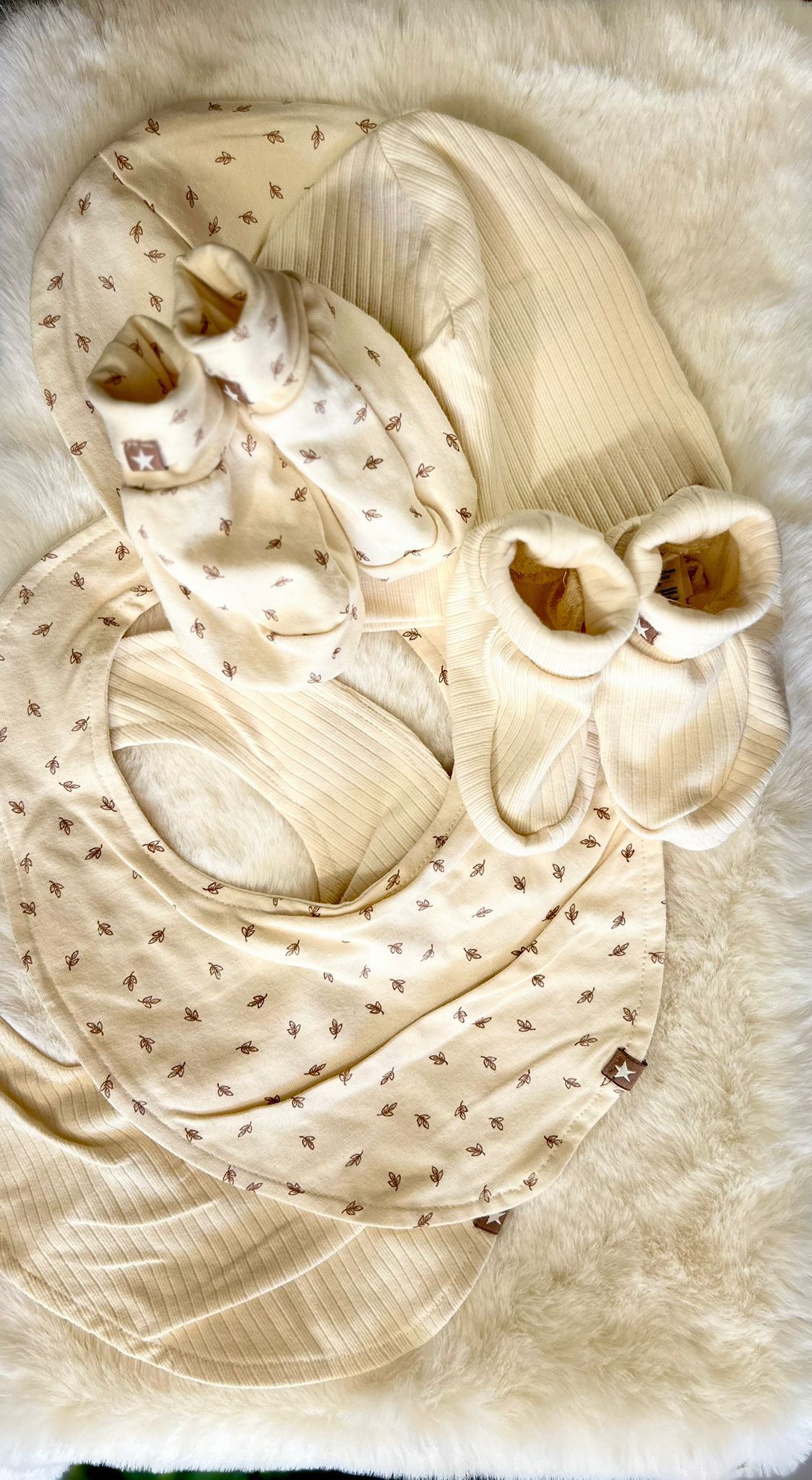Decorazione da parete a forma di gufo, di colore beige e intrecciata, con grandi occhi e piume dalla texture particolare.