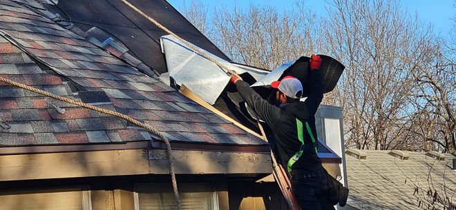 Person in white gloves repairs a window frame with tools on a wooden floor, including screwdrivers and pliers,
