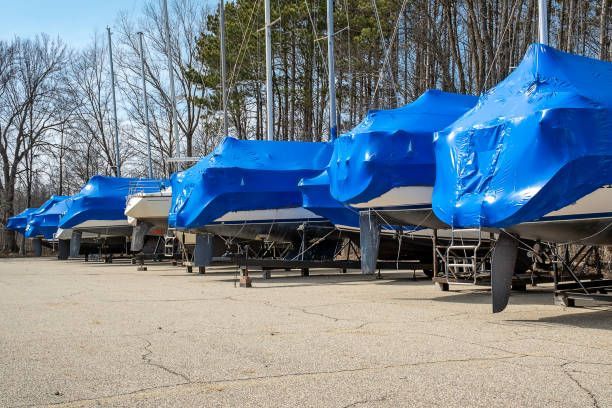 Row of boats covered in outdoor storage lot.