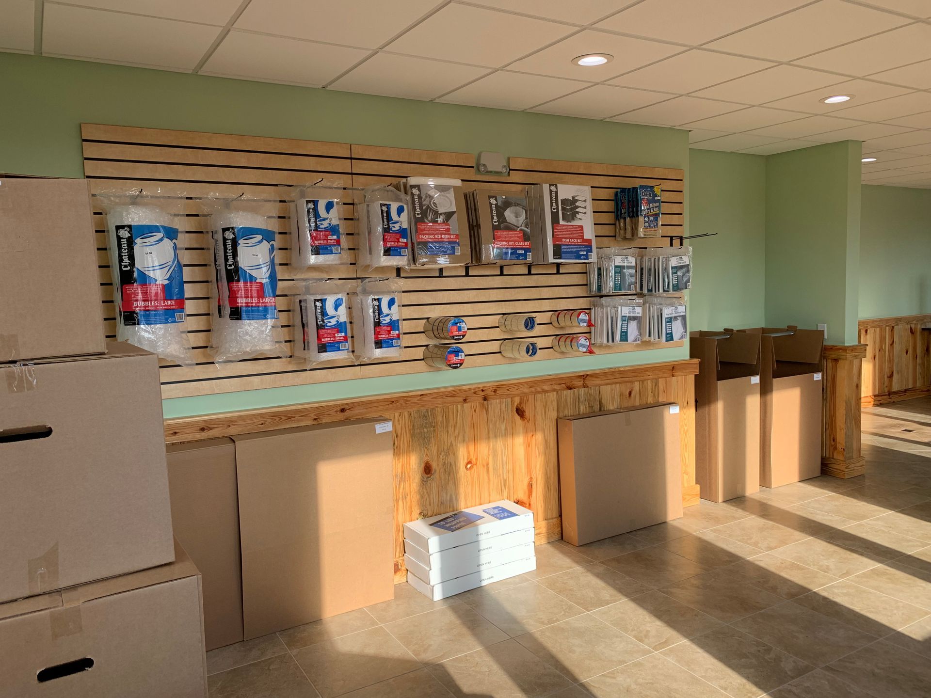 Storage supplies display: boxes, packing materials, shelving. Interior lit by overhead lights.