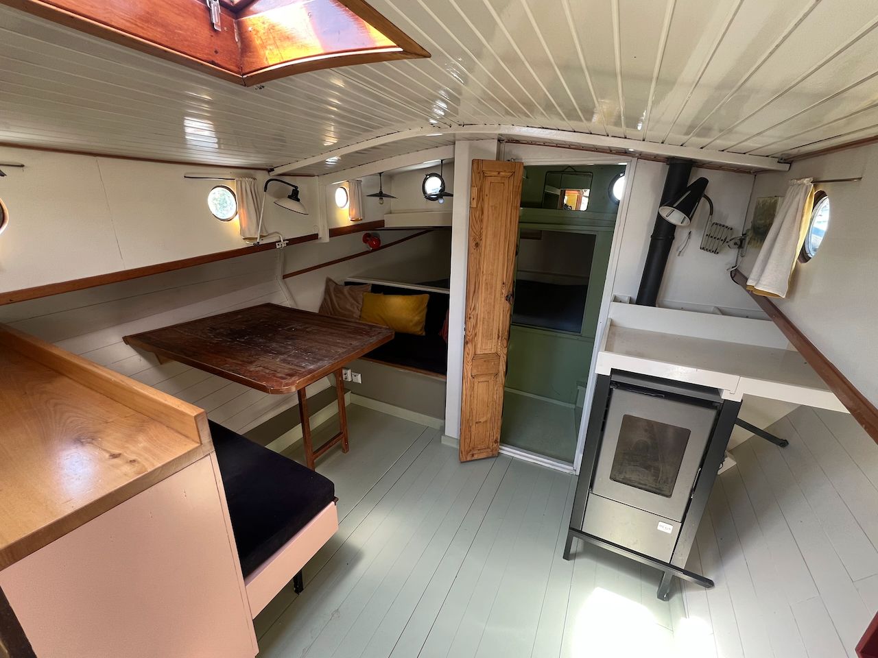 interieur van de Wijde Blik met tafel, houten lambrisering, patrijspoorten en een kachel/verwarming.