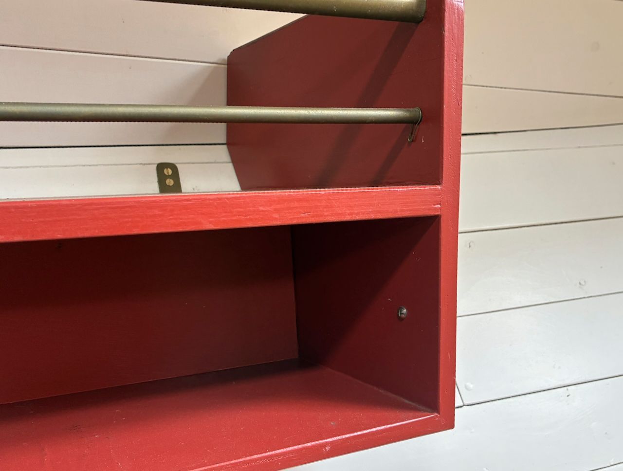Detail van de boekenkast tegen een witte, horizontale houten lambrisering.