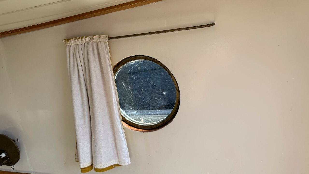 Gordijntjes voor de patrijspoort van de Wijde Blik