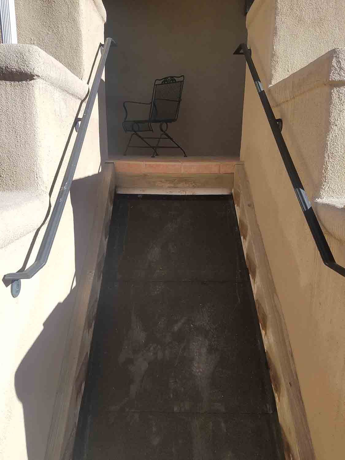 There is a chair in the corner of the hallway.