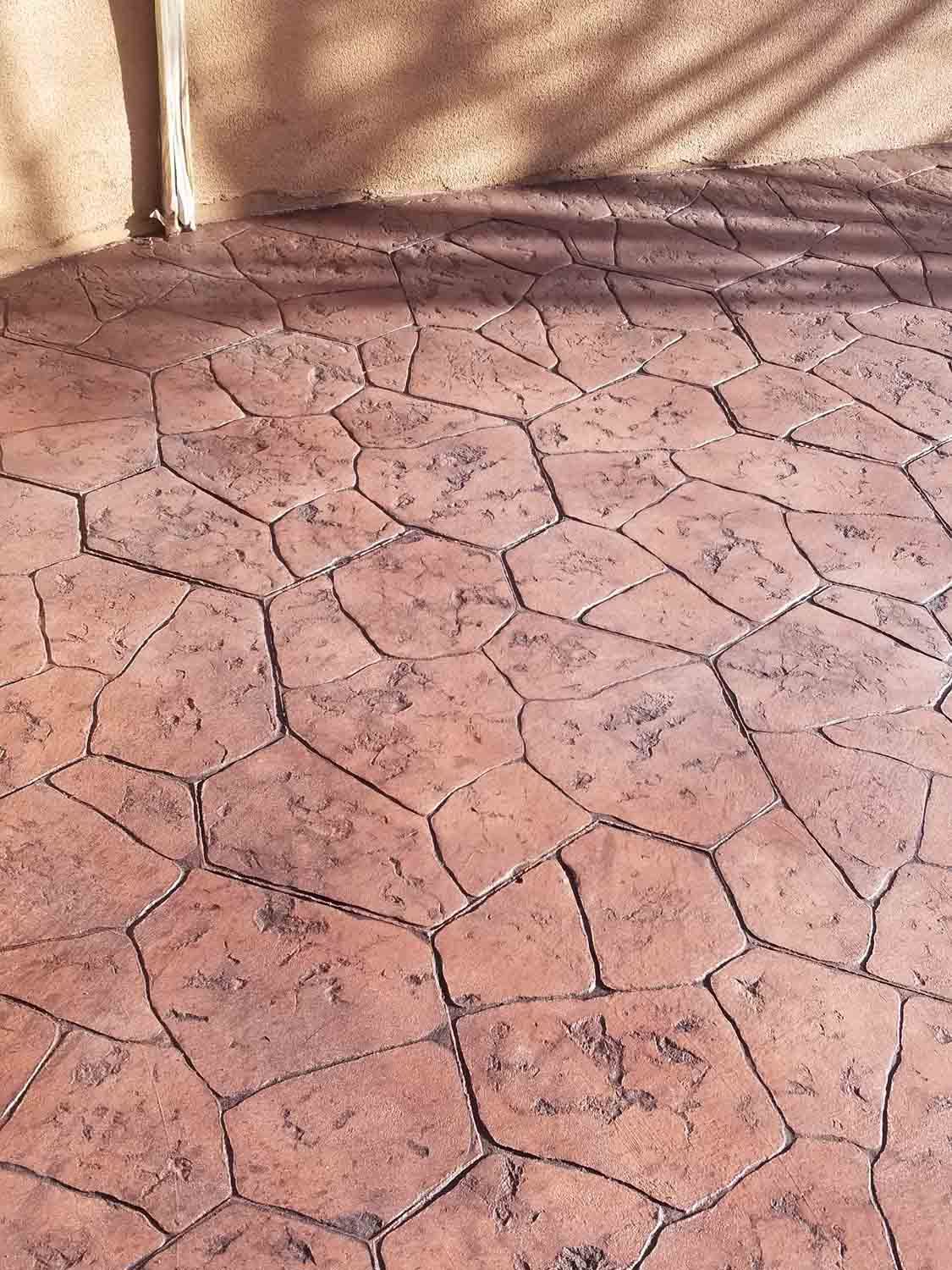 A close up of a brick floor with a shadow of a tree on it.