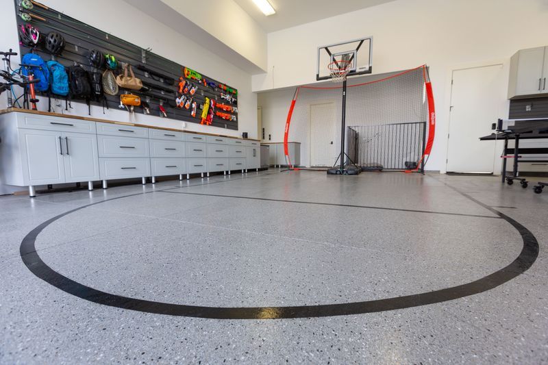 A garage with a basketball hoop and a circle on the floor.