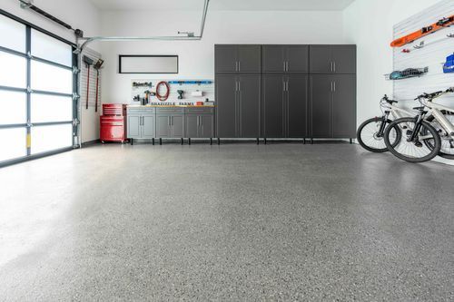 A garage with bikes parked in it and a garage door.