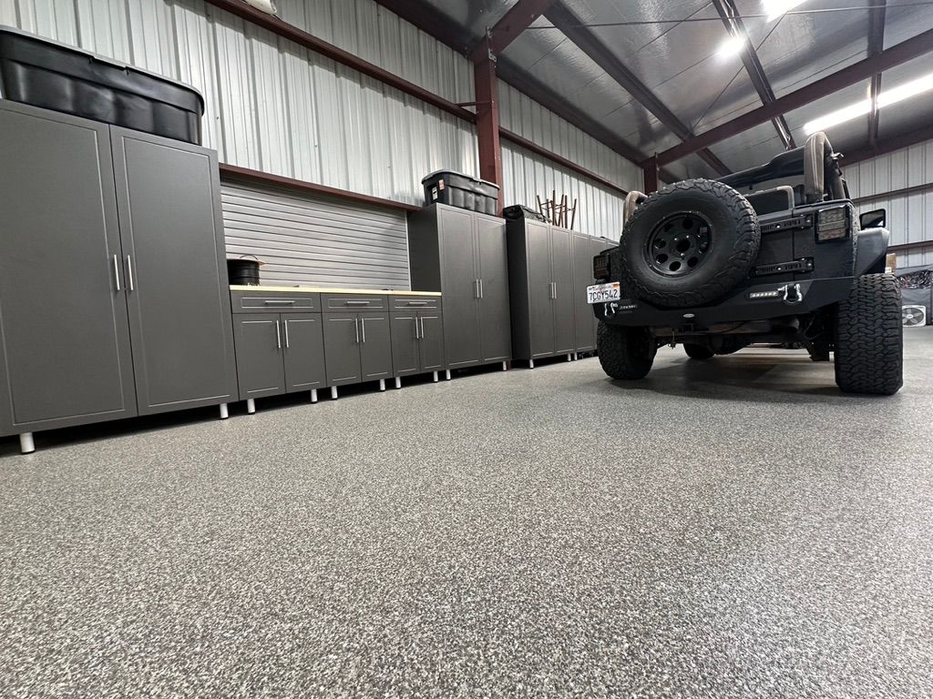 A jeep is parked in a garage with a concrete floor.