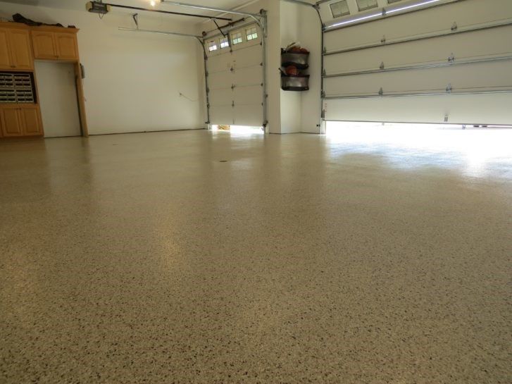 A garage with a garage door open and a shiny floor