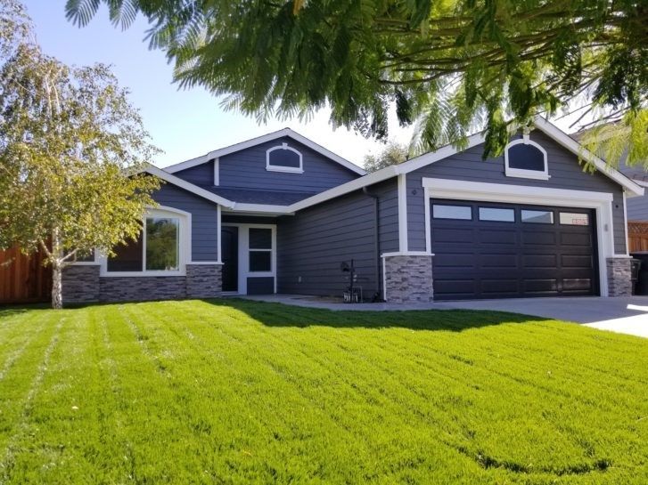 A house with a lush green lawn in front of it.
