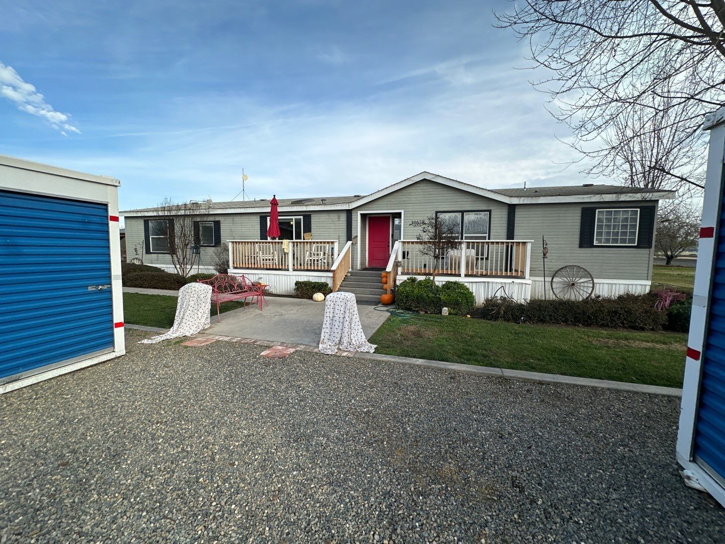 A mobile home with a blue garage in front of it.