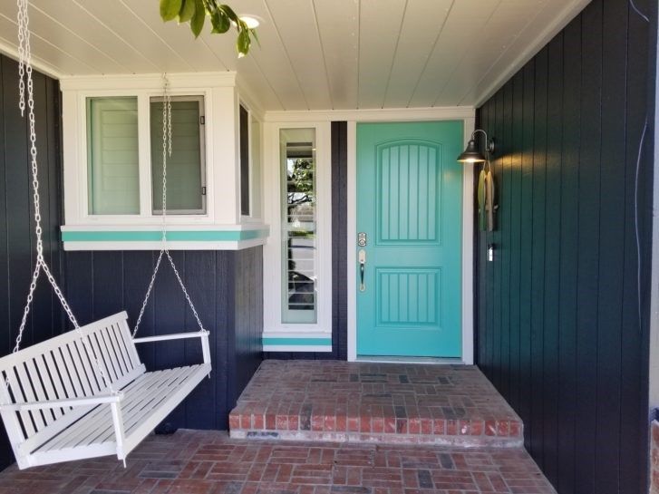 A porch with a swing and a blue door
