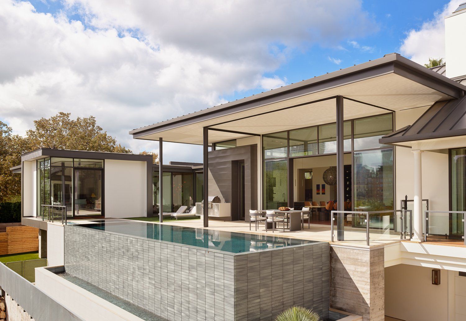 A house with a large swimming pool in front of it