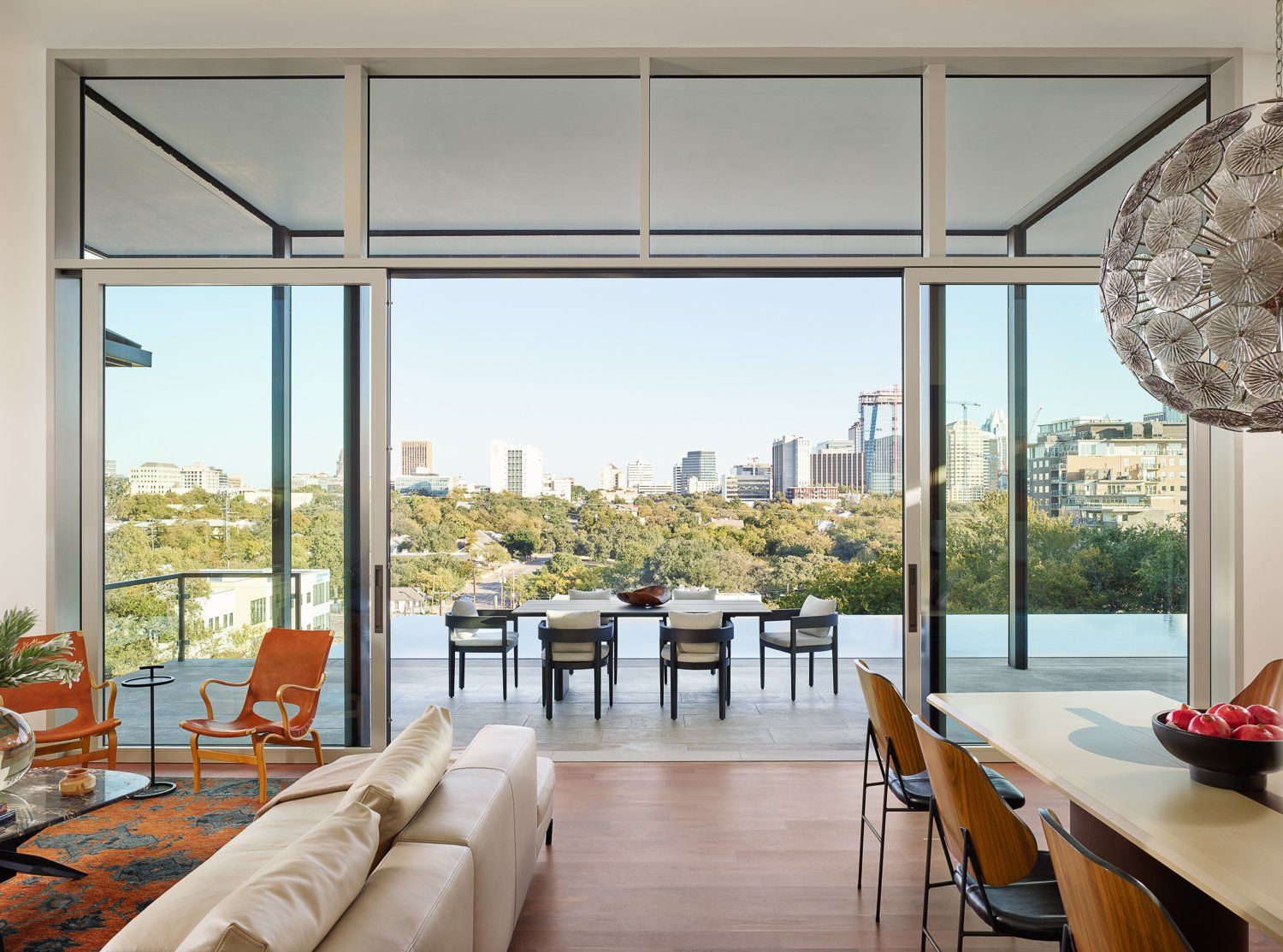 A living room and dining room with a view of a city