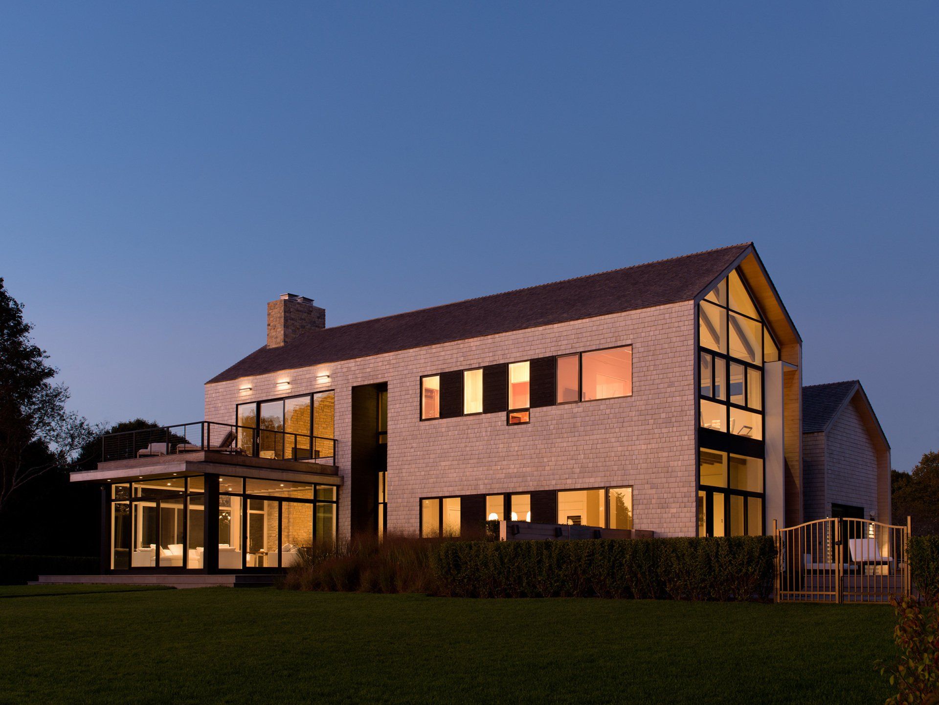 A large house with a lot of windows is lit up at night