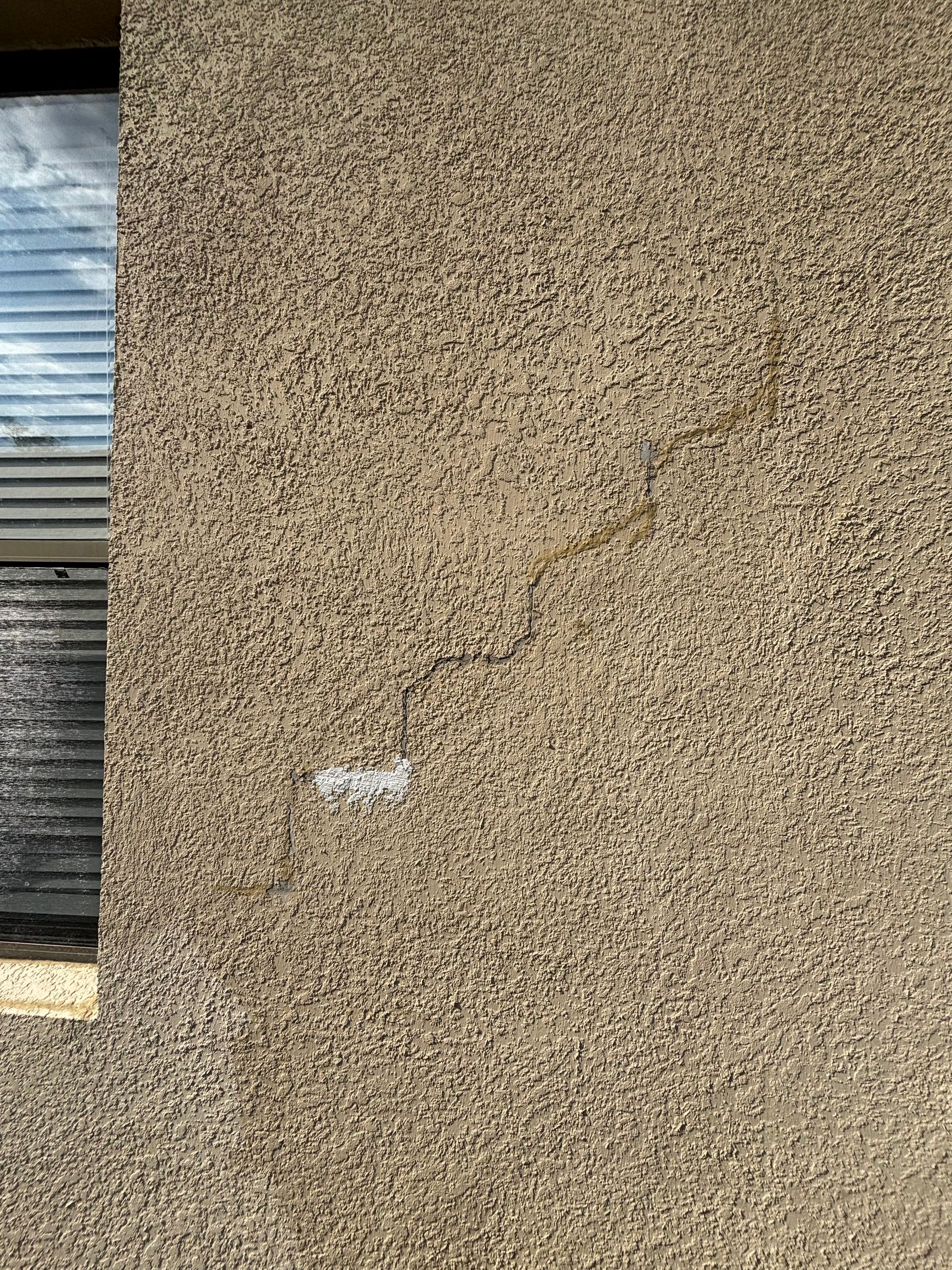 Sealing hairline stucco cracks before painting a home in a DeLand HOA