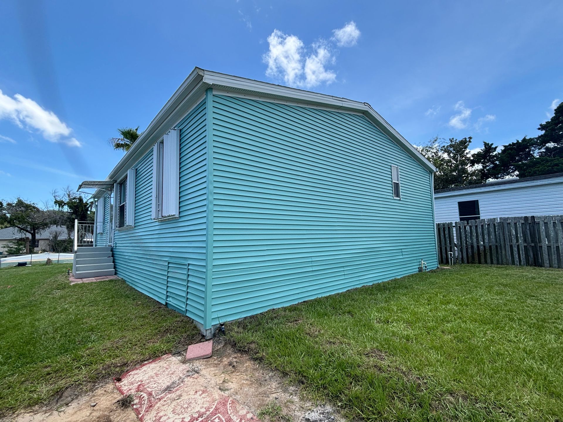 Completed exterior house painting project on vinyl siding home in Edgewater with smooth spray finish
