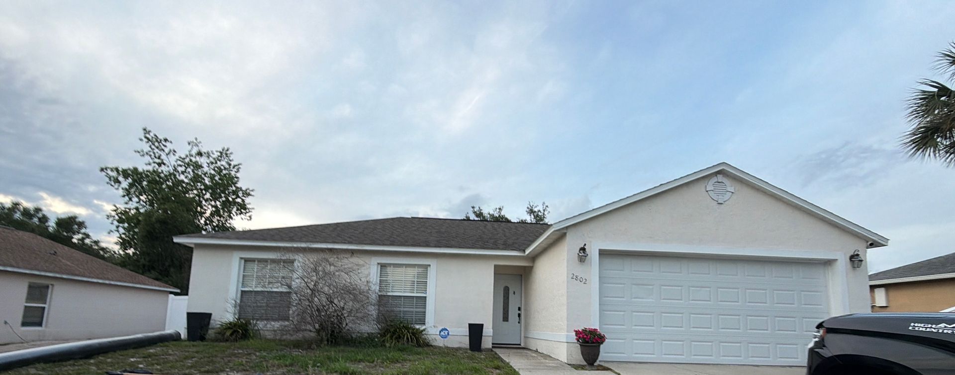 Professional exterior painting preparation on a block home in Deltona, FL, including pressure washing, crack filling, and removal of loose peeling paint.