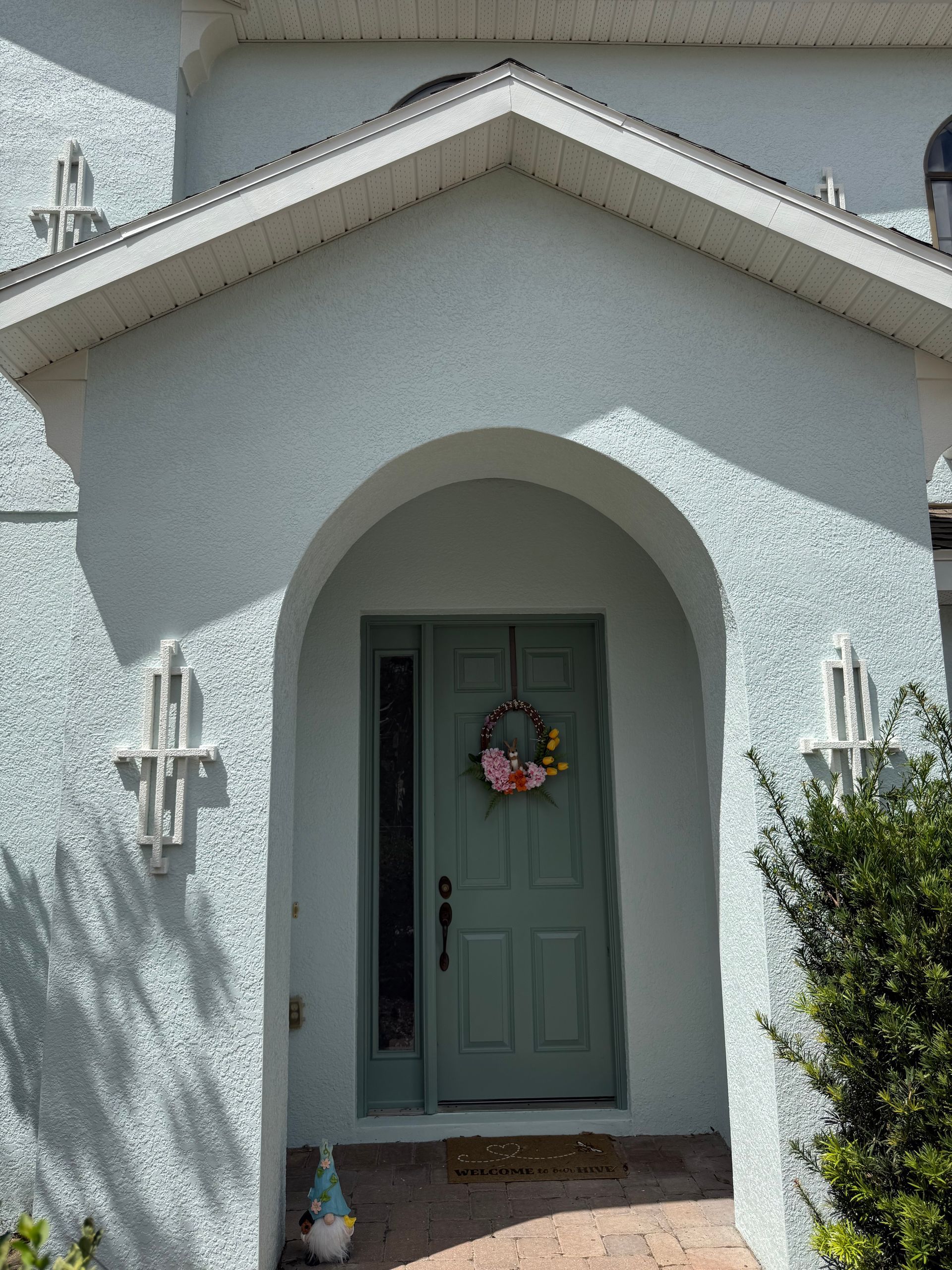Refinishing and painting a wood front door on a two-story stucco home in DeLand