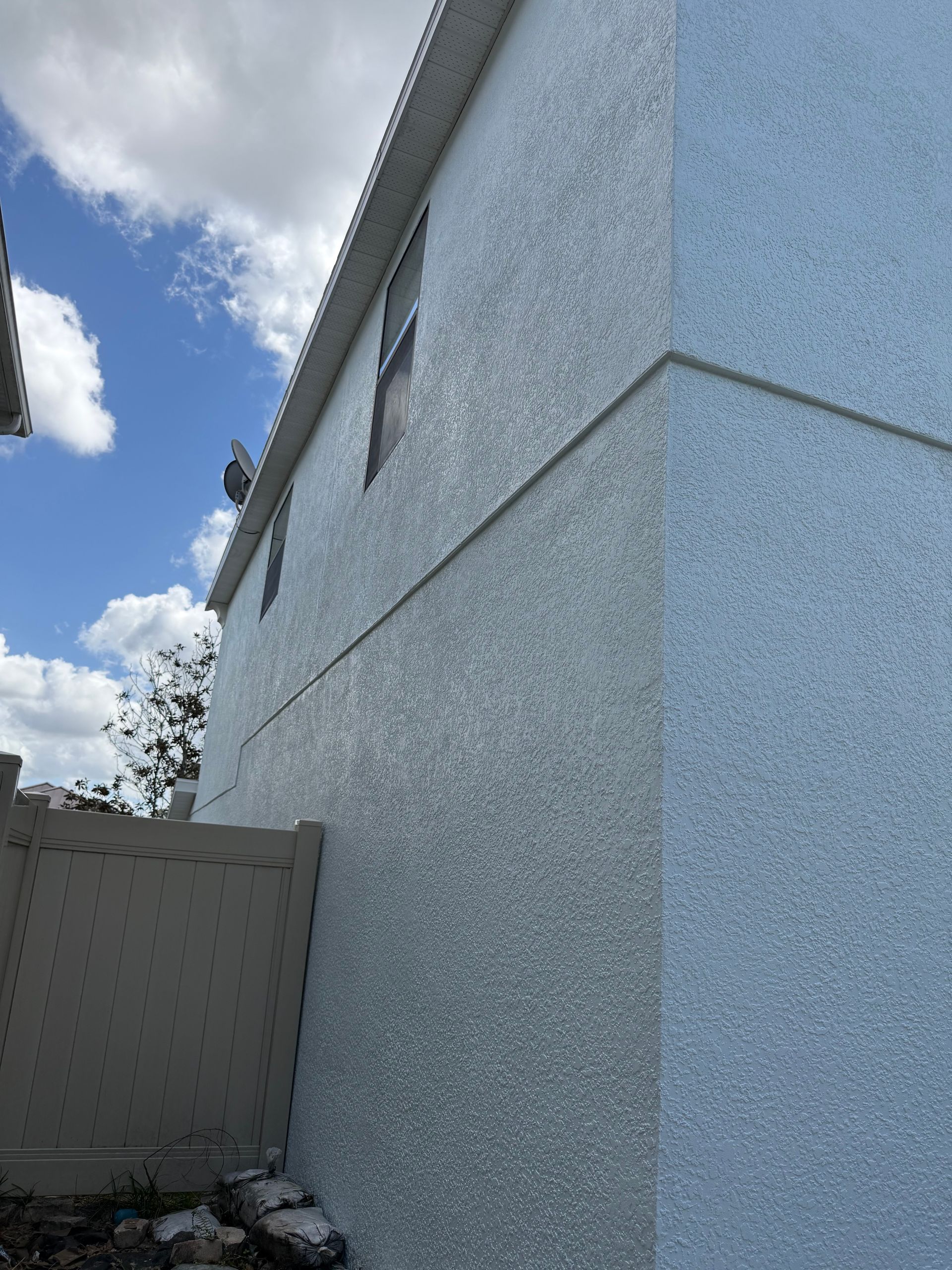 Professional application of DTM paint on metal soffits of a DeLand HOA home