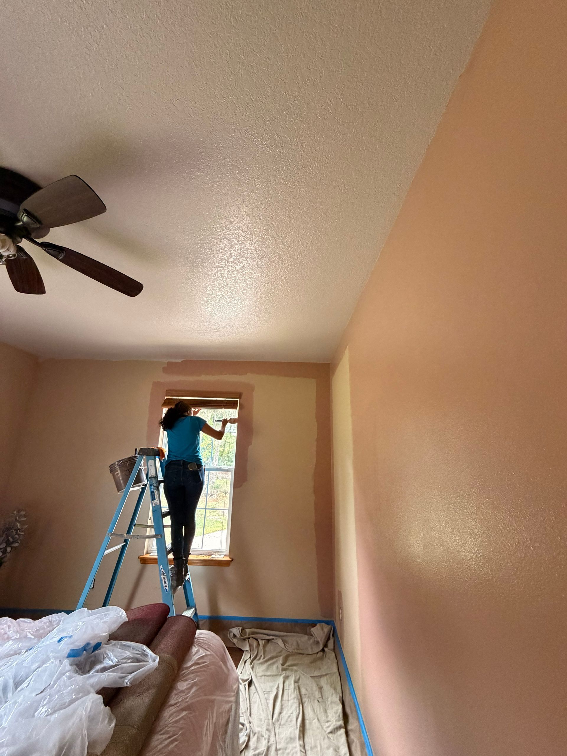 employee painting guest bedroom