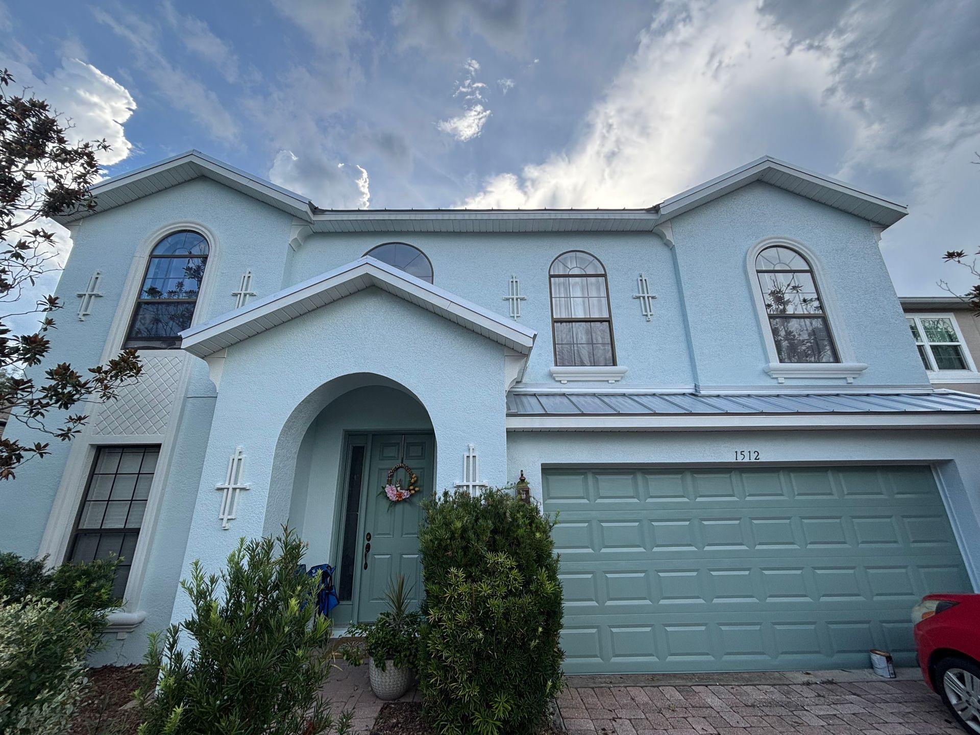 Beautifully restored two-story stucco home in DeLand, Florida professionally repainted by Atlantic Finish using premium Sherwin-Williams Emerald Exterior Paint.