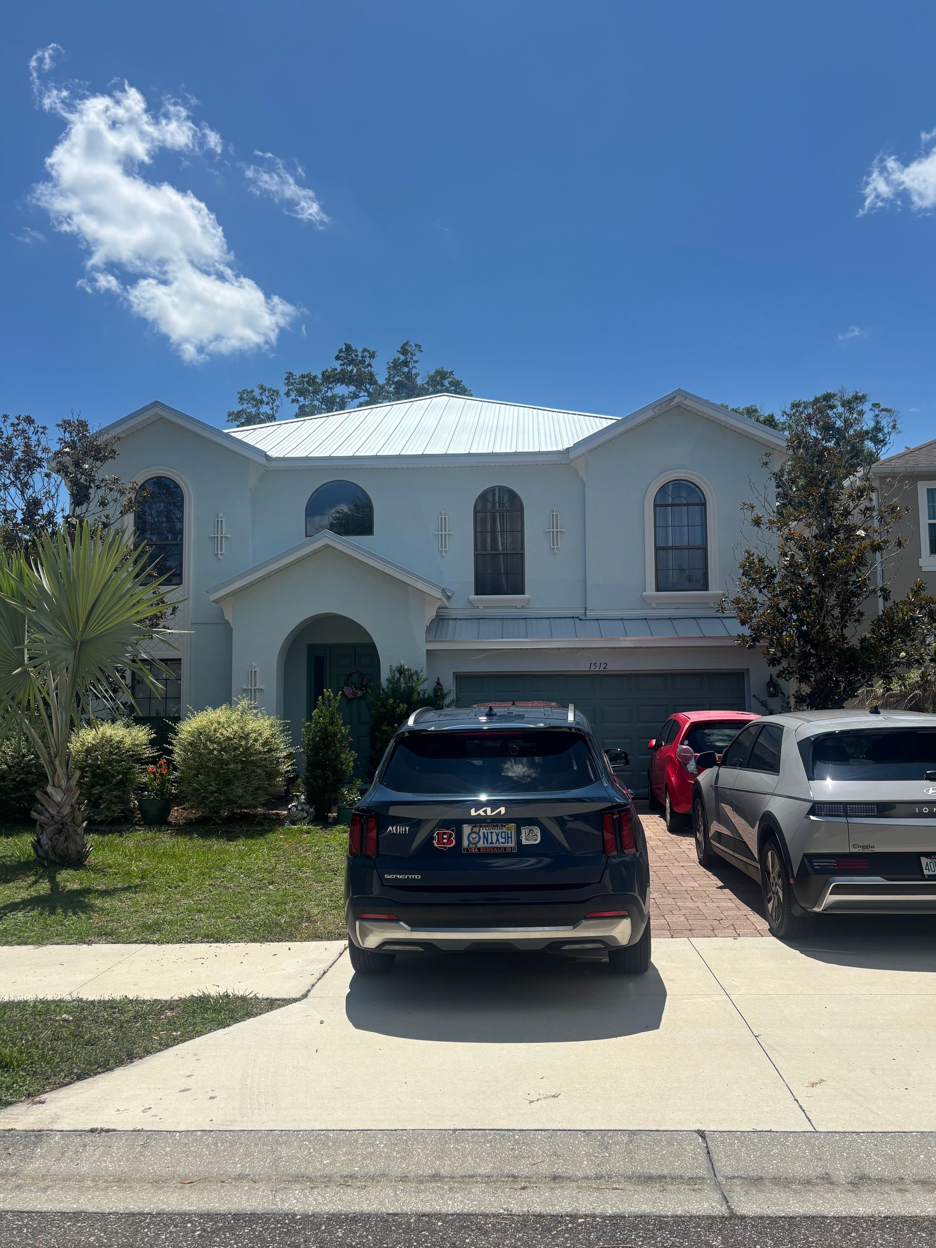 Completed exterior repaint of a two-story stucco home in DeLand, FL featuring three custom Sherwin-Williams color matches, premium Duration paint, and professionally refinished front door by Atlantic Finish.