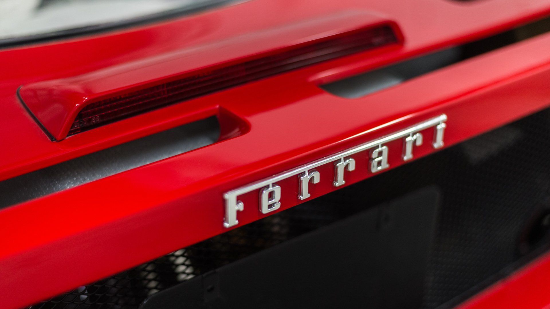 Close-up of a red Ferrari sports car rear with the Ferrari badge and taillight details