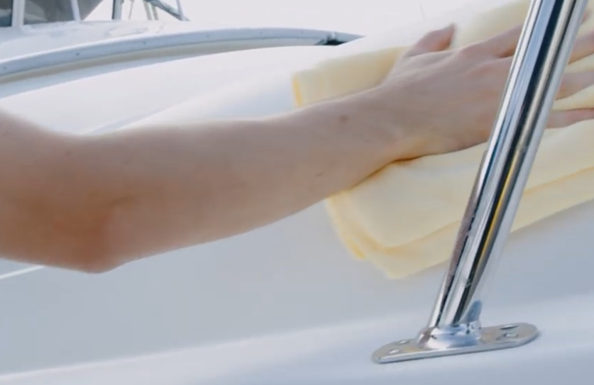 operator with microfiber towel shinning boat.