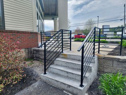 Professional welder fabricating outdoor metal stairs on a job site - NRK Welding LLC