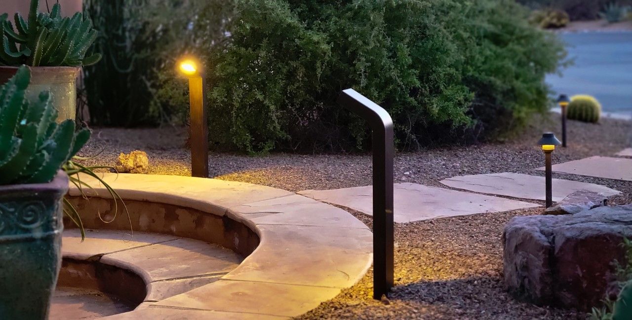 Pathway with stone pavers and landscape lighting at dusk.