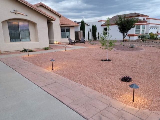 House exterior with walkway lined with lights, and gravel landscaping.
