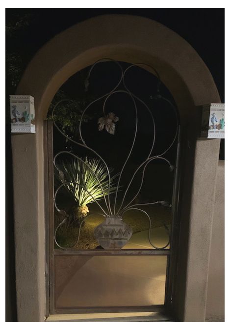 Ornate metal gate with scrolling design and stone accents.