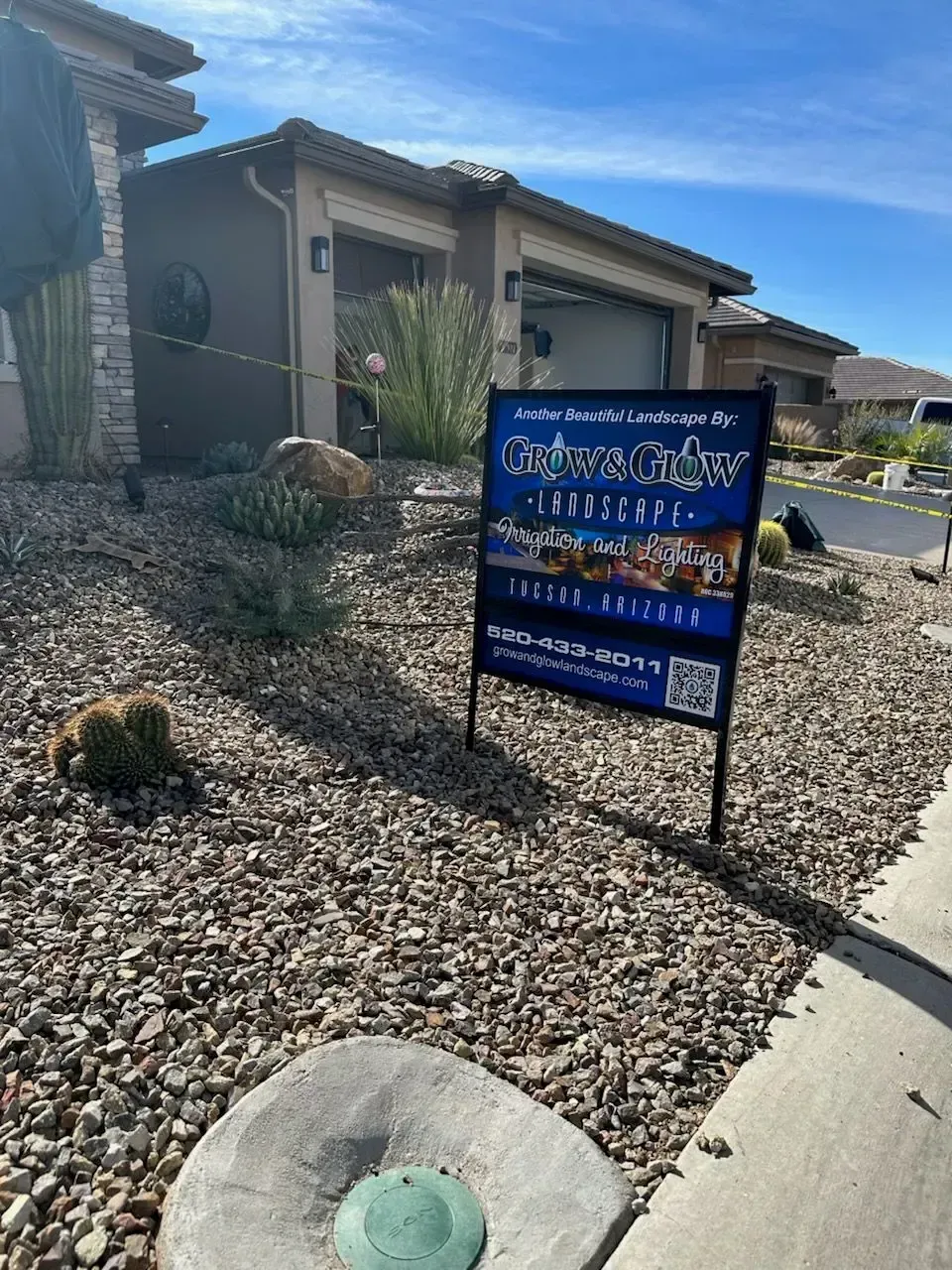 Real estate sign in front of a house with gravel landscaping; sunny day, blue sky.