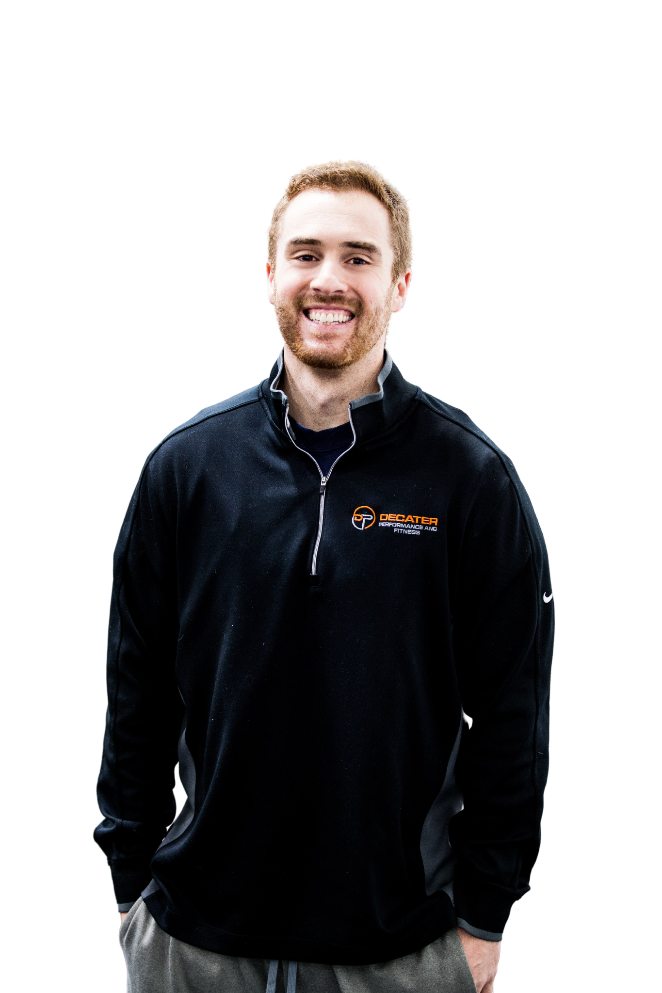 Smiling man in black zip-up sweatshirt, hands in pockets. White background.
