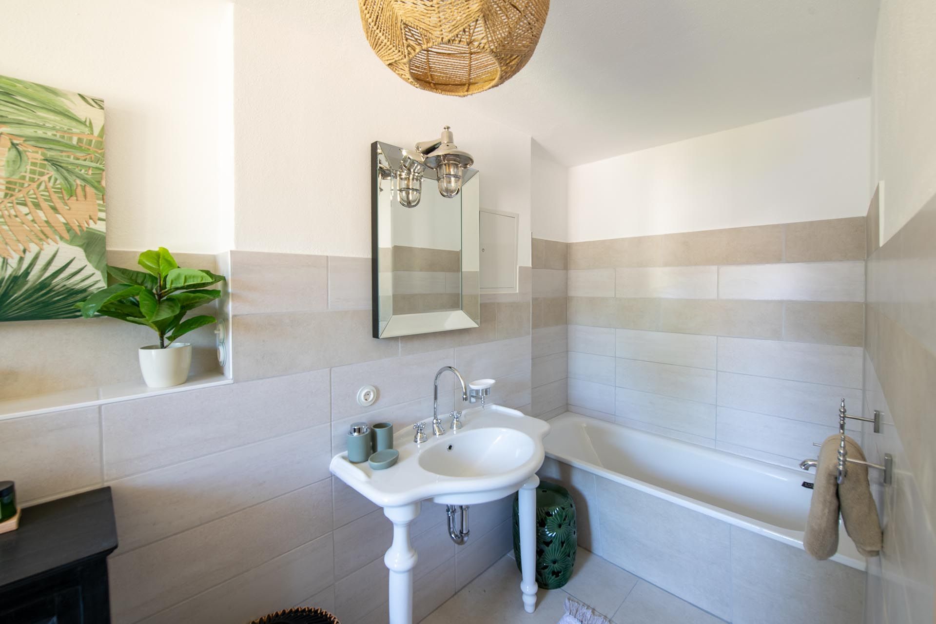 Ein Badezimmer mit Waschbecken, Spiegel und Badewanne.