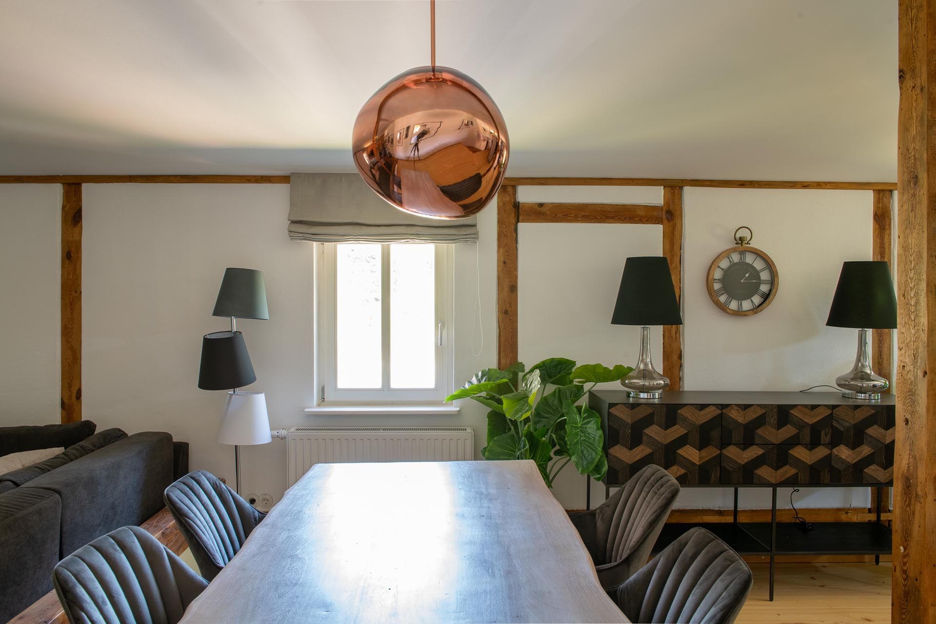 Ein Esszimmer mit einem Tisch und Stühlen und einer Uhr an der Wand.