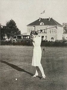 Ein Schwarzweißfoto einer Frau, die einen Golfschläger schwingt
