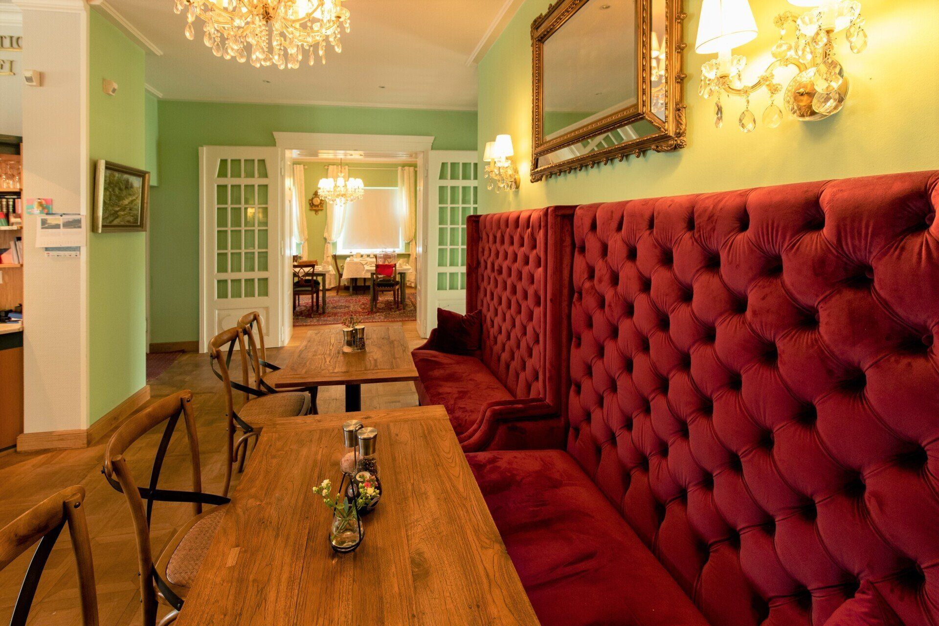 Ein Esszimmer mit Tischen und Stühlen und einer roten Bank.