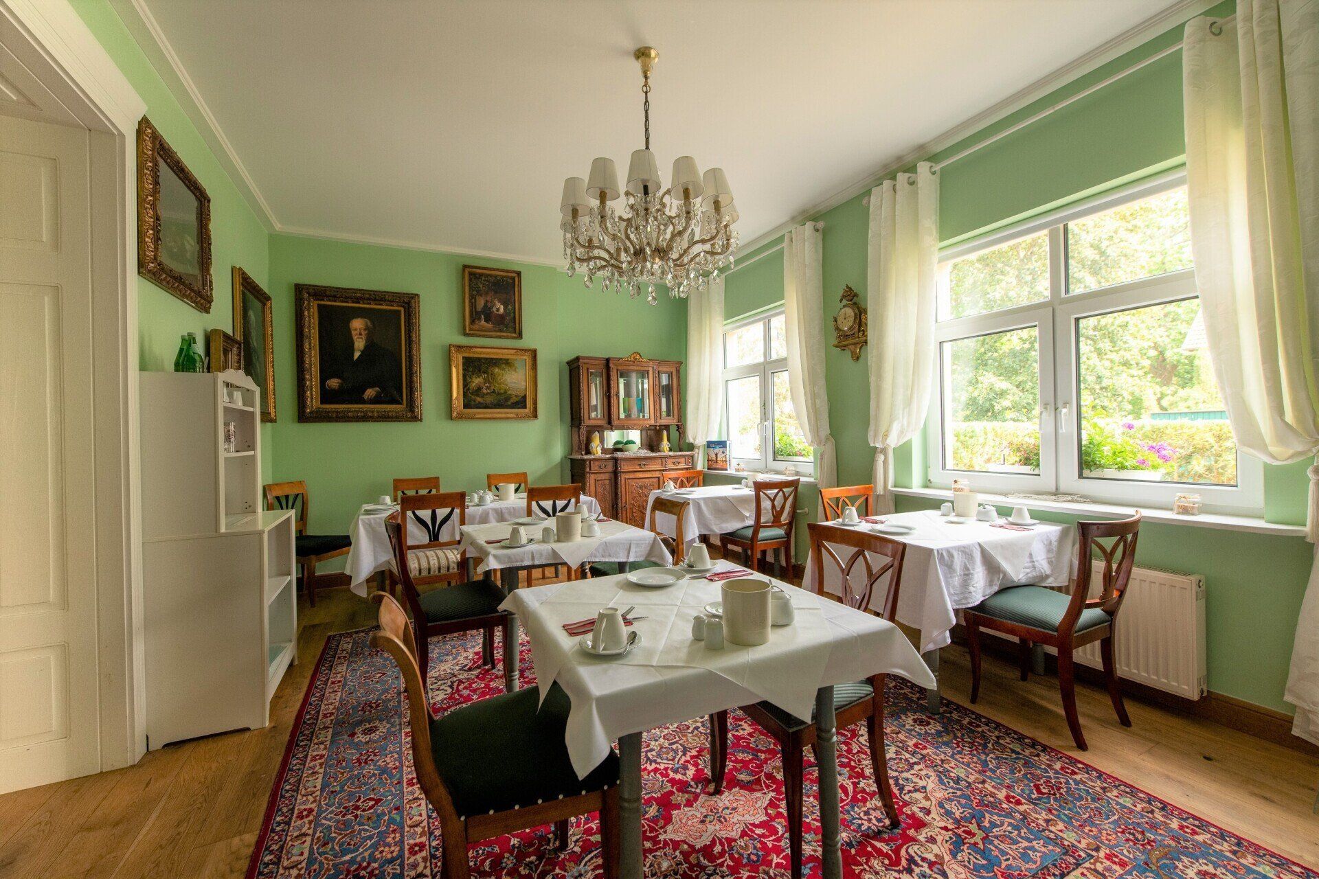 Ein Esszimmer mit Tischen und Stühlen und einem Kronleuchter.