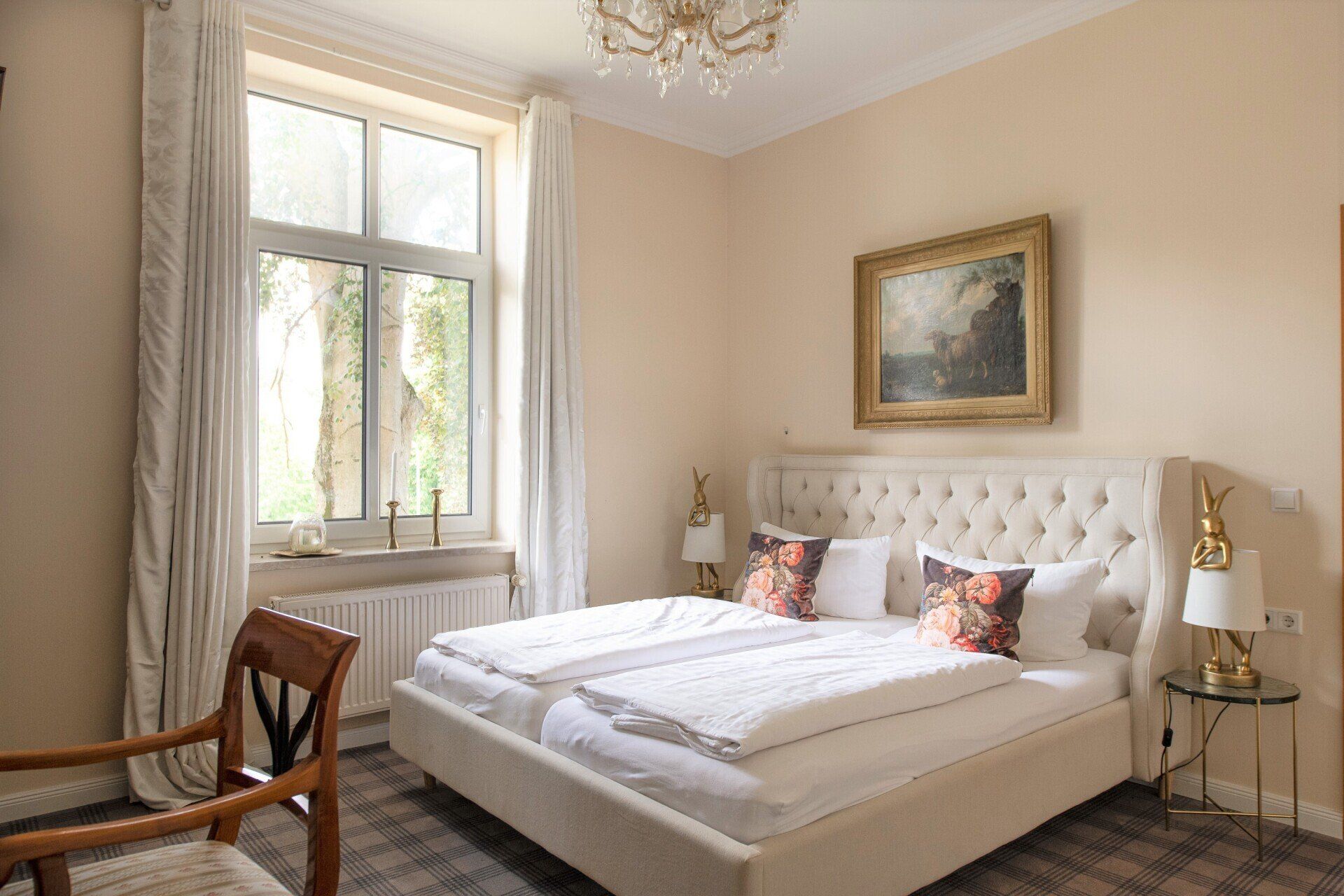Ein Schlafzimmer mit Bett, Stuhl, Lampen und Fenster.
