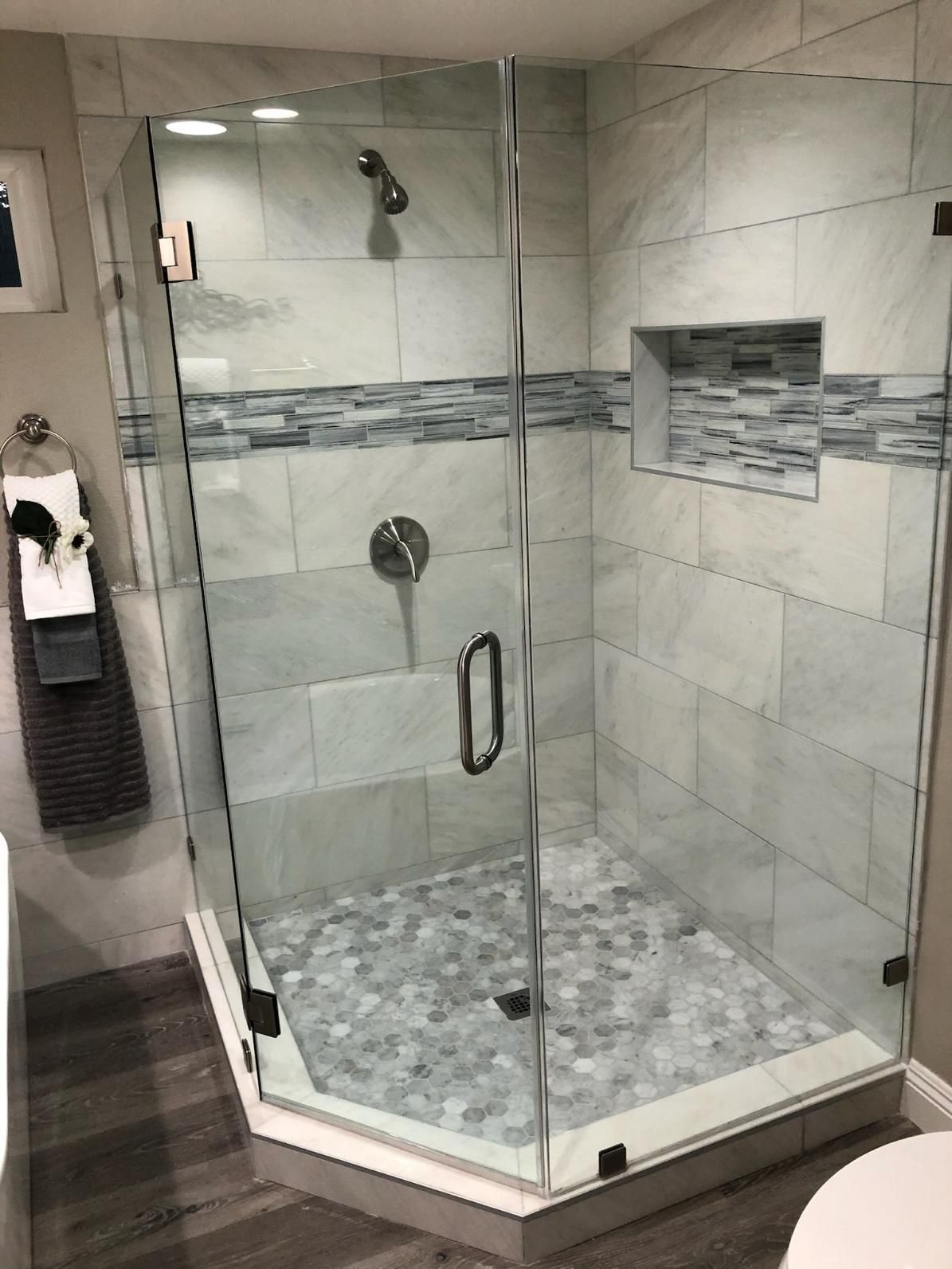 Modern tiled bathroom with a glass walk-in shower and pebble stone floor