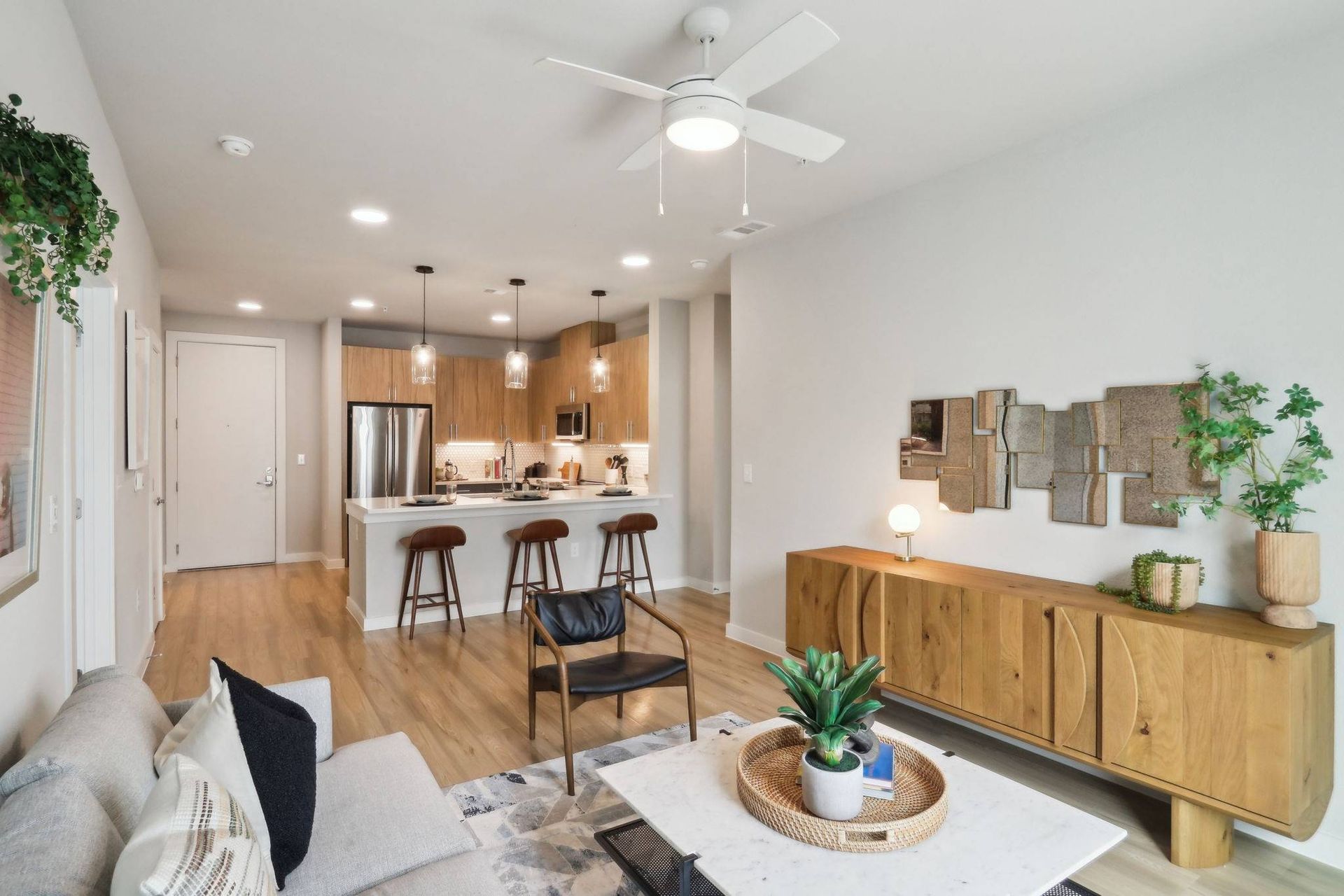 Open-concept living area with kitchen island, wood floors, and seating