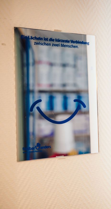 Ein Poster mit einem Smiley darauf hängt an einer Wand