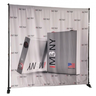 Two silver M3NY boxes displayed on a branded backdrop, one leaning open with red buttons and a logo.