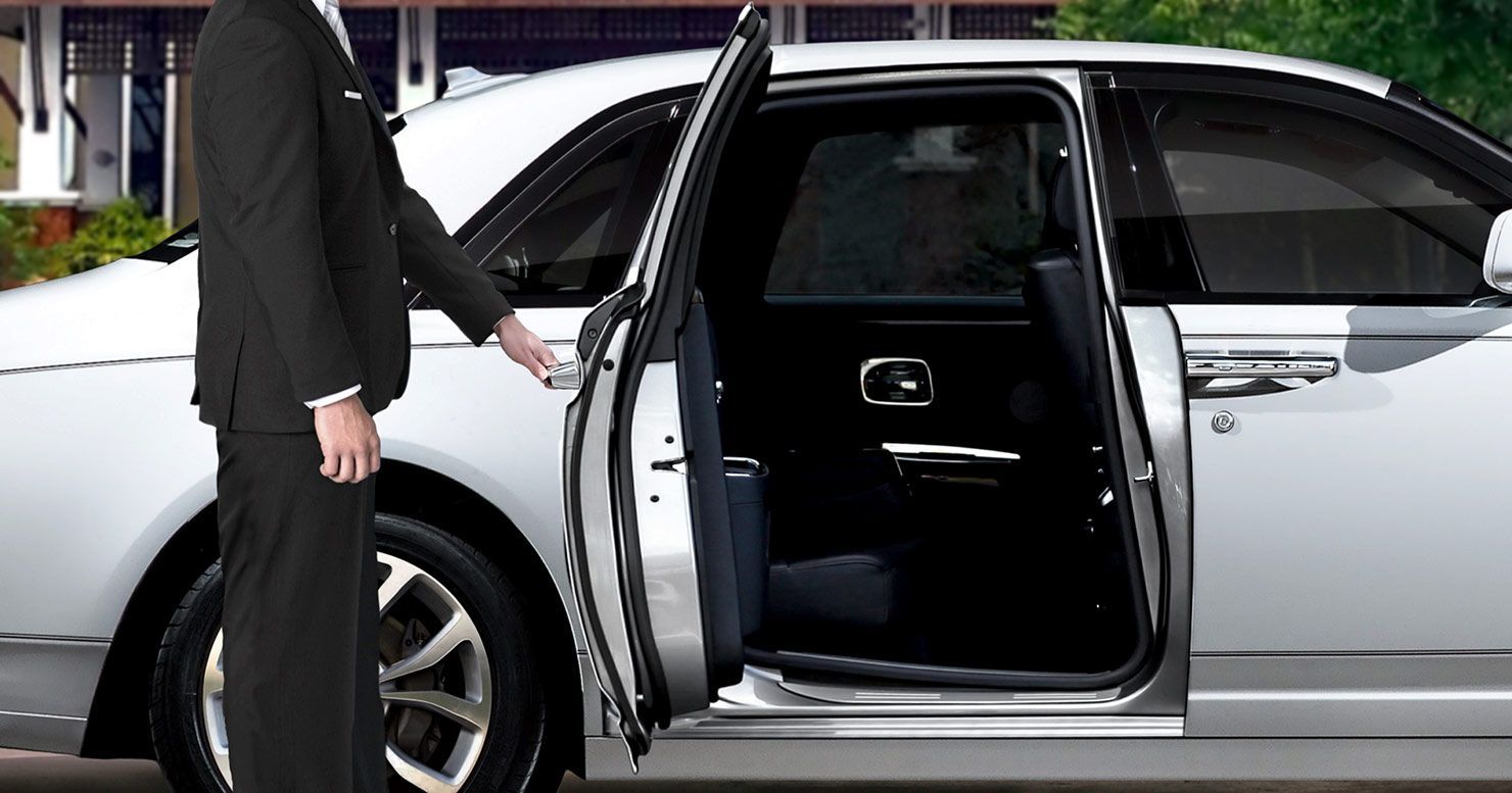 A Man in a Suit is Opening the Door of a White Car — Territory Limousine Service in Kakadu, NT