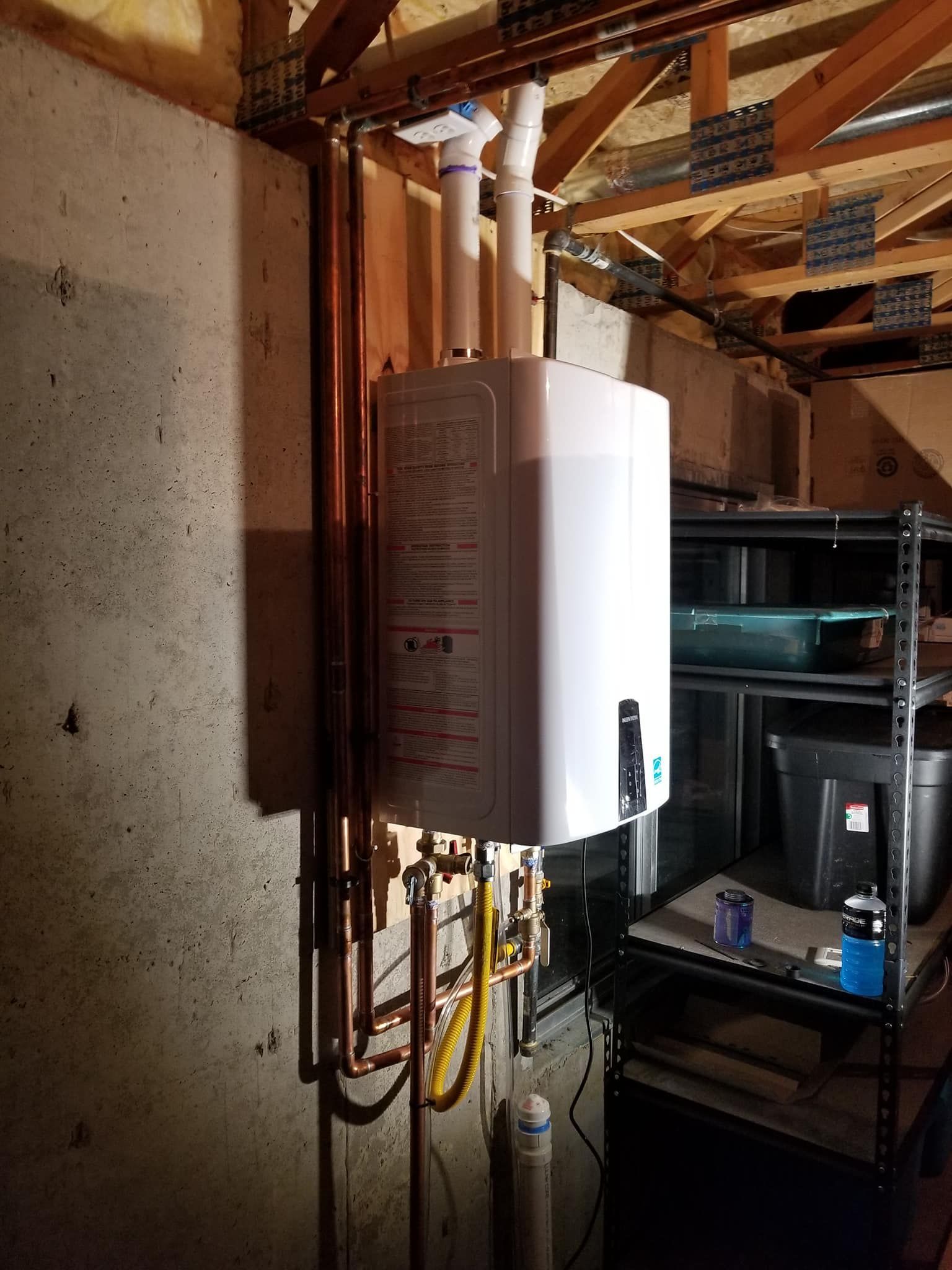 White water heater with copper pipes in a basement utility area рядом shelving and exposed beams