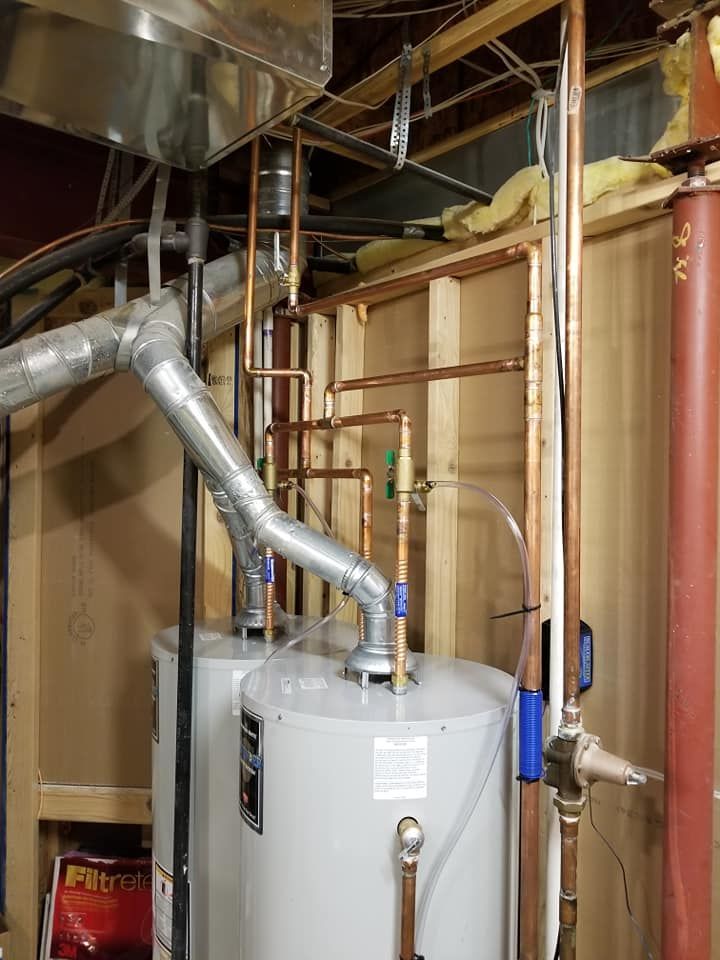 Water heater and ductwork in an unfinished basement utility area.