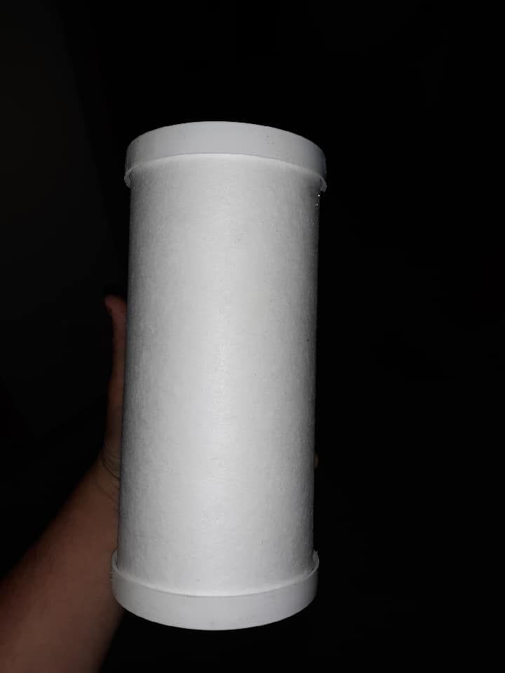 White cylindrical container held upright against a dark background