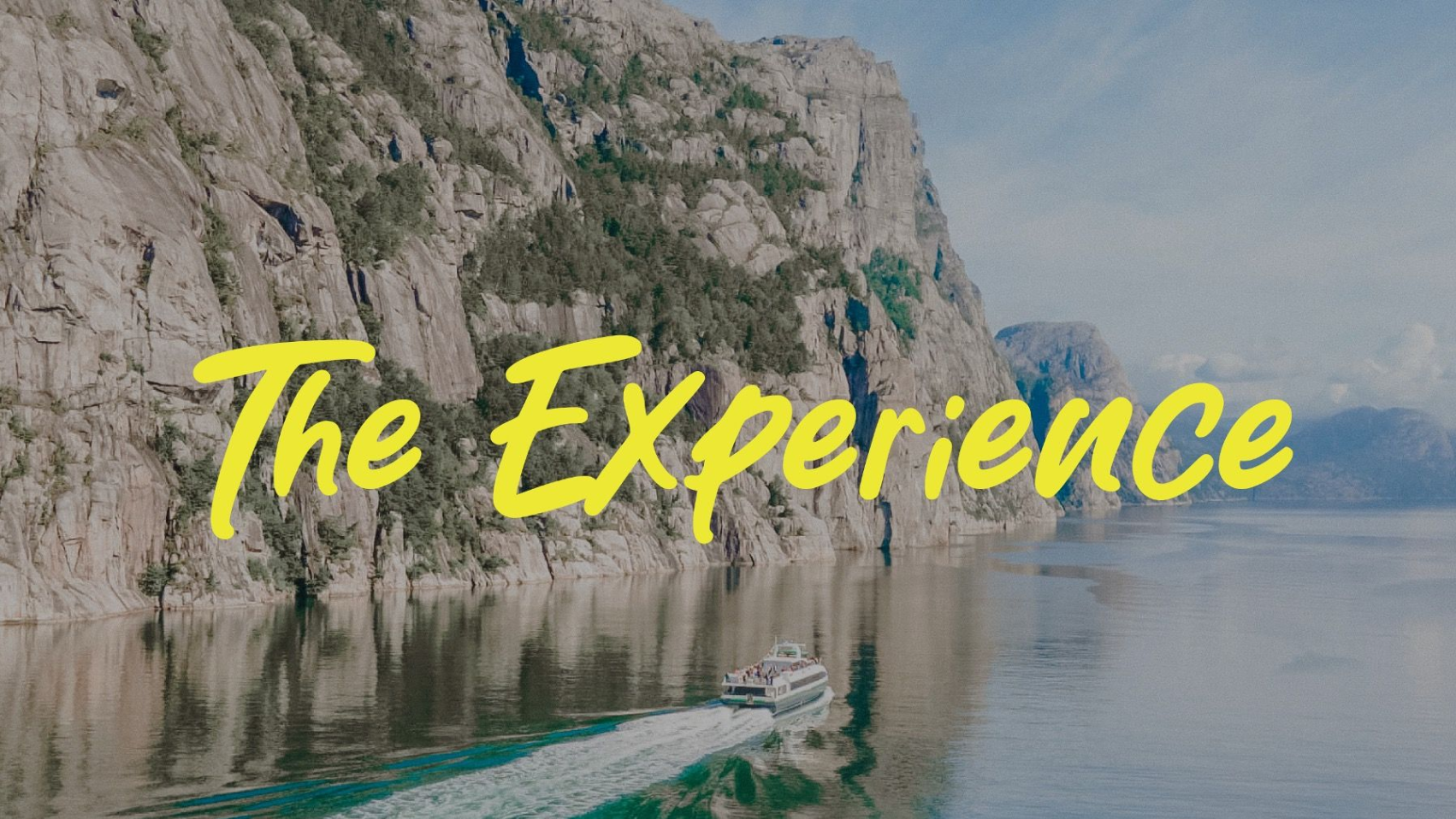 Boat sailing on a fjord with steep cliffs and the words 